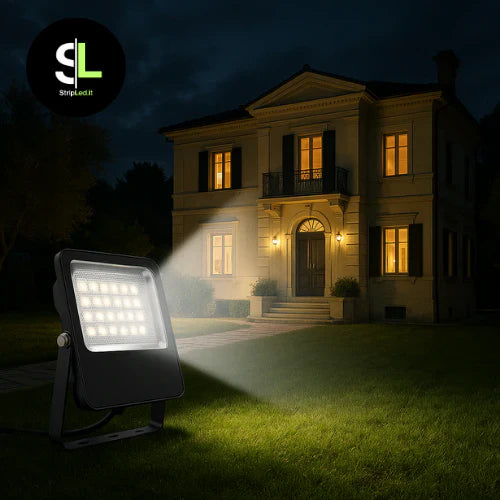 Faro LED da esterno che illumina la facciata di una casa di notte con logo StripLed.it