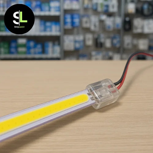 Connettore alimentazione per strip LED 8mm collegato alla striscia su banco negozio con logo StripLed.it