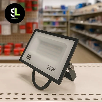 Faro LED 20W su bancone di un negozio di materiale elettrico e logo StriLed.it