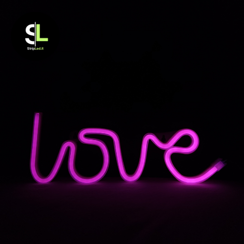 Insegna luminosa LED neon love accesa con luce rosa intensa.
