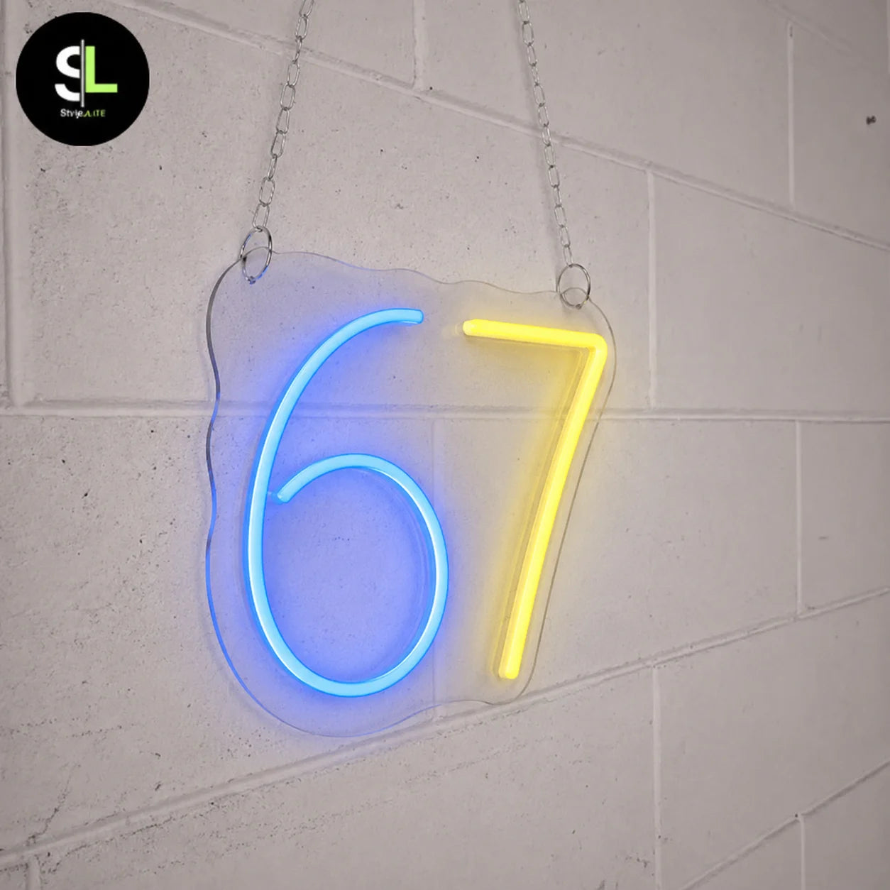 Insegna neon LED con numero 67 su plexiglass sagomato, 6 blu e 7 giallo accesi, sospesa con catena su parete bianca