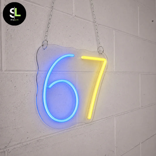 Insegna neon LED con numero 67 su plexiglass sagomato, 6 blu e 7 giallo accesi, sospesa con catena su parete bianca