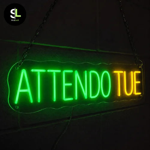Insegna neon LED ATTENDO TUE verde e gialla accesa con supporto in plexiglass trasparente