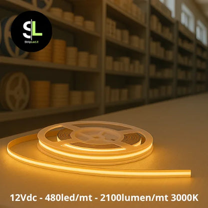 Striscia LED COB 12V bianco caldo 3000K accesa su banco in magazzino e logo StripLed.it”
