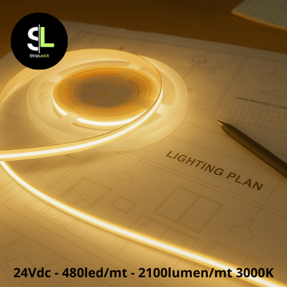 Striscia LED COB 24V bianco caldo 3000K accesa su piano tecnico con luce continua e uniforme.