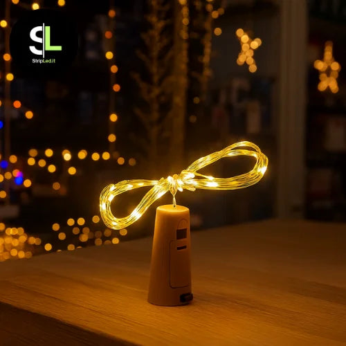 Tappo luminoso bianco caldo per bottiglia con filo LED in negozio natalizio e logo StripLed.it