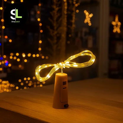 Tappo luminoso bianco caldo per bottiglia con filo LED in negozio natalizio e logo StripLed.it